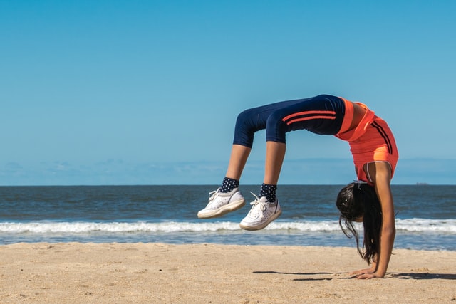Person with long hair doing a backflip like she's flexible. She knows suffering is optional.
